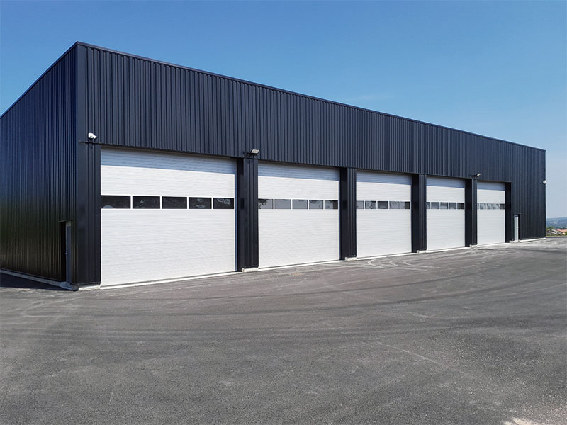 White sectional doors with roller shutter like design and vision windows